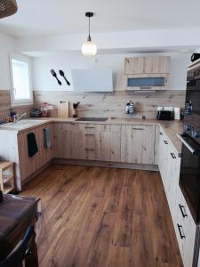 cocina con armarios de madera y suelo de madera en Maison El Refugi - A 15min station ski Formiguères, en Puyvalador