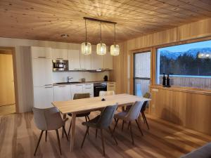 a kitchen and dining room with a wooden table and chairs at Blickfang Bregenzerwald in Langenegg