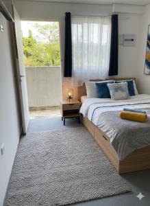 um quarto com duas camas e uma janela grande em Pousada Ideal - Estúdios com Cozinha & Terraço Exclusivo - Suítes Econômicas no Guarujá