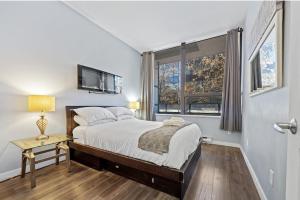 una camera da letto con un letto e una finestra di Cozy 1 Bedroom Downtown Central a Vancouver