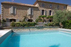 a house with a swimming pool in front of a building at Clos Du Père Clément in Visan