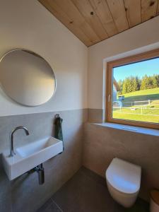 a bathroom with a sink and a window at Blickfang Bregenzerwald in Langenegg +40 photos