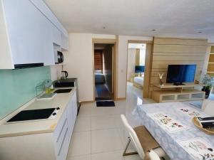 a kitchen and a living room with a table at Beachfront Patong Hillside Modern Apartment in Patong Beach +5 photos