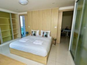 a bedroom with a large bed with white sheets and pillows at Beachfront Patong Hillside Modern Apartment in Patong Beach