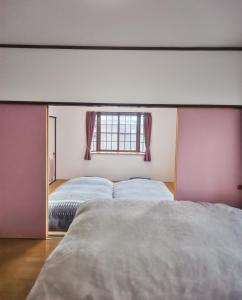 Un pat sau paturi într-o cameră la 民泊よこてこよ