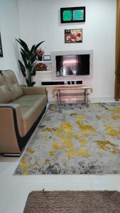 Una sala de estar con un sofá y un televisor. en Liza Homestay, en Bachok