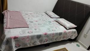 Una cama pequeña con manta y almohadas. en Liza Homestay, en Bachok