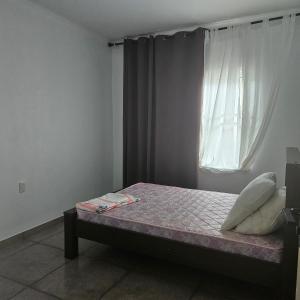 ein Bett in einem Zimmer mit Fenster in der Unterkunft Jawala Mansion in Paramaribo