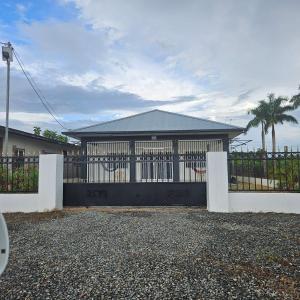 a house with a black gate and a fence at Jawala Mansion in Paramaribo