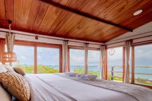 a bedroom with a bed with a view of the ocean at Blu Galapagos Sustainable Waterfront Lodge in Puerto Ayora