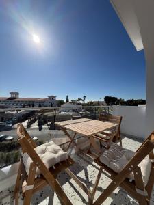 a patio with a table and chairs on a balcony at The Retro Suite Kato Paphos 2 min to the beach in Paphos