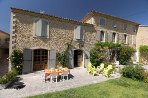 a patio with a table and chairs in front of a building at Clos Du Père Clément in Visan