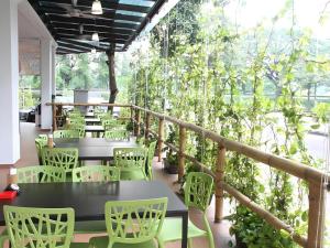 a patio with tables and chairs and trees at Peach Hill Hotel & Cafe in Kampong Sungai Rinting