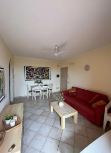 Una sala de estar con un sofá rojo y una mesa. en Seaside apartment in Shell Beach, en Santa Maria