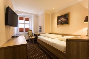 a hotel room with a bed and a television at Meiser Altstadt Hotel in Dinkelsbühl