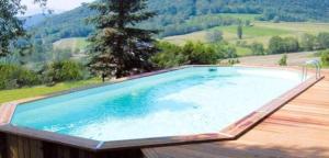 a swimming pool on a deck with a view of a mountain at Anniversaire, Vacances, Team Building, 1 H de Toulouse in Puymaurin