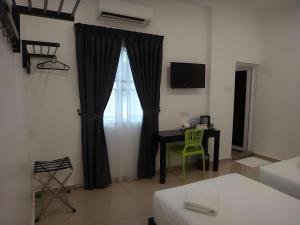 Hotel Seri Geliga في Kampong Geliga Besar: غرفة مع طاولة ونافذة مع مكتب