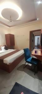 a bedroom with a bed and a desk and a chair at HOTEL RAJBHOG indore in Indore