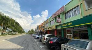 una fila de autos estacionados al lado de una calle en OYO 89760 Harmoni Inn Hotel, en Sri Gading