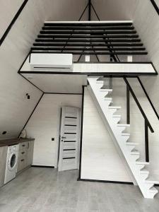 a white staircase in a room with a washing machine at Frame&Forest in Kolochava