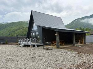 a black building with a picnic table in front of it at Frame&Forest in Kolochava