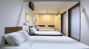 two beds in a hotel room with two beds at SPOT ON 91178 Motel Impian in Seri Manjung