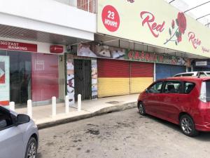 a red car parked in front of a building at SPOT ON 90077 Cherry's Lodge in Lahad Datu