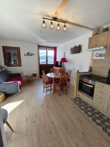 Una cocina y una sala de estar con mesa y sillas. en T2 cosy à Puyvalador - Ski & lac, en Puyvalador