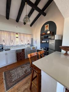 a kitchen with white cabinets and a table and chairs at Vistas al Mar in Great Brak River