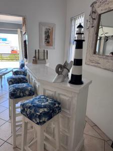 a room with a counter with stools and a lighthouse at Sea Jewel in Pearly Beach