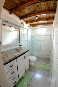 a bathroom with a sink and a toilet at Casa Perto das melhores praias Florianópolis, 8 pessoas, ar condicionado, tv, wifi, cozinha completa, lavanderia, in Florianópolis