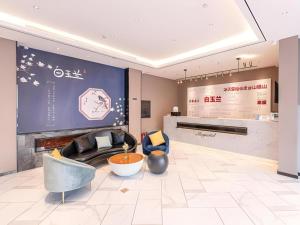 uma sala de estar com sofá e lareira em Magnotel Business Harbin Railway Station Qiulin Museum Metro Station em Harbin