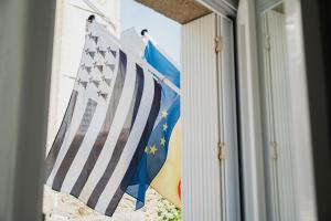 una bandera estadounidense y banderas en una casa en Hôtel Quic en Groigne, en Saint-Malo