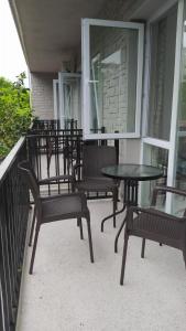 a group of chairs and tables on a porch at Emzari's Apartment in K'obulet'i