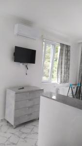 a kitchen with a sink and a tv on the wall at Emzari's Apartment in K'obulet'i