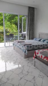 a bedroom with two beds and a balcony at Emzari's Apartment in K'obulet'i