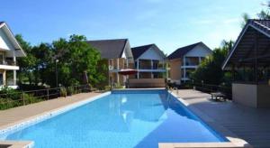 uma grande piscina em frente a algumas casas em OYO 619 Water Palm Resort em Ban Nam Tok