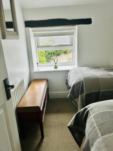 ein kleines Schlafzimmer mit zwei Betten und einem Fenster in der Unterkunft L'al Cottage, Sockbridge in Penrith