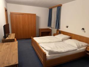 Brauereigasthof Falter في ريغين: غرفة نوم بها سريرين وتلفزيون بداخلها