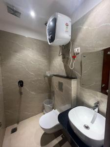 ニューデリーにあるHotel Jupiterの白いトイレと洗面台のあるバスルーム