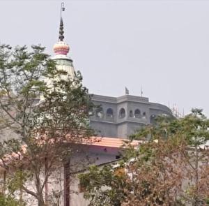 a building with a tower on top of it at Atithi Niwas, Best hotel near khandoba temple Jejuri in Jejūri