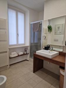 a bathroom with a white sink and a shower at Trento Living in Trento