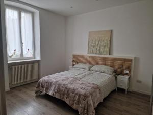 a bedroom with a large bed and two windows at Trento Living in Trento