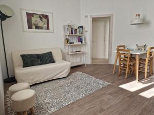 a living room with a white couch and a table at Trento Living in Trento