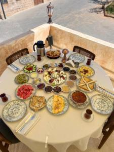 un tavolo bianco con piatti di cibo sopra di Merani Hotel a Midyat