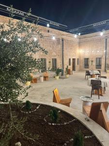 un ampio patio con tavoli e sedie in un edificio di Merani Hotel a Midyat