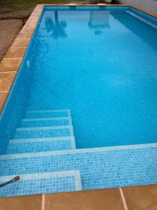 una piscina con azulejos azules en el suelo en Alleinstehende Villa mit Pool-Finca Gabriela, en Oliva