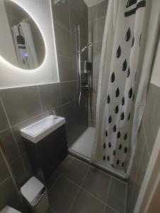 uma pequena casa de banho com um chuveiro e um lavatório. em Gästezimmer nahe Therme Bad Wörishofen em Bad Wörishofen