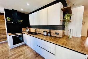 cocina con armarios blancos y suelo de madera en Luxury full center and near Lake!, en Gérardmer