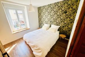 Un dormitorio con una cama con sábanas blancas y una ventana. en Luxury full center and near Lake!, en Gérardmer